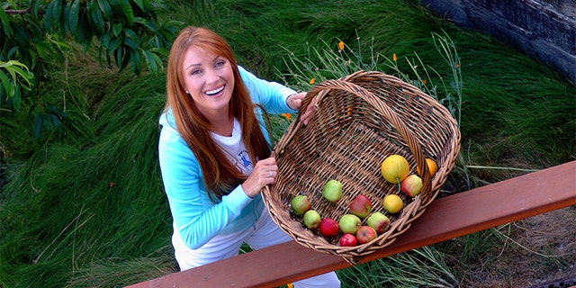 Actress and artist Jane Seymour stands on the deck of her home overlooking the Pacific Ocean with items picked from her garden in Malibu, California.