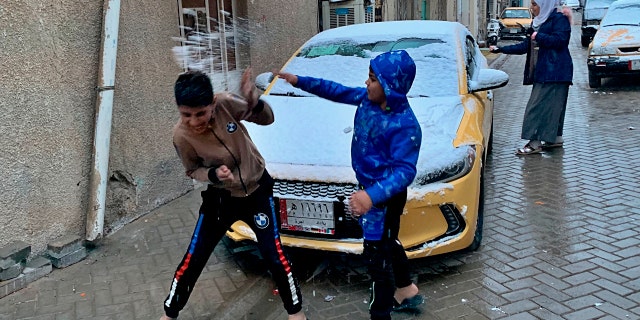 Iraqi children play in the snow in Baghdad, Iraq, Tuesday, Feb. 11, 2020.