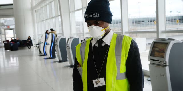 An airport employee working at JFK is seen wearing a mask on Friday, Jan. 31, out of concern over the coronavirus outbreak.