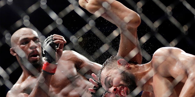 Jon Jones, left, delivering a kick to Dominick Reyes, right, during the bout at UFC 247 in Houston. (AP Photo/Michael Wyke)