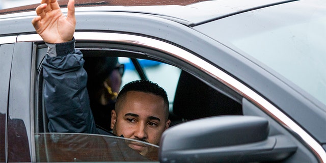New York Police Department Lt. Jose Gautreaux, who was shot in the arm by a gunman who opened fire in a police precinct in the Bronx, waves to his colleagues as he is released from Lincoln Hospital in the Bronx on Monday.