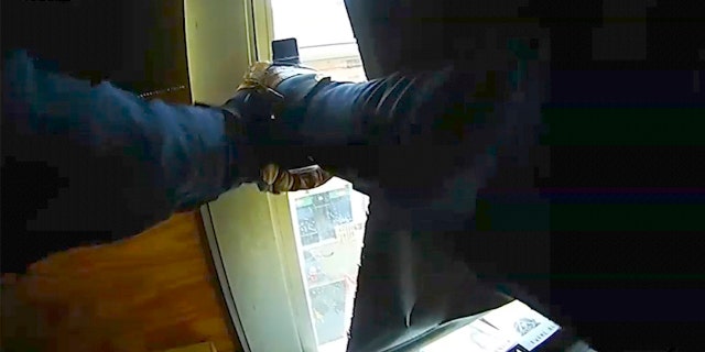 In this Dec. 10, 2019 image made from newly released video provided by the Jersey City Police Department via the New Jersey Attorney General's Office, a Jersey City police officer fires his weapon from the window of a Catholic school during a fierce gun battle in Jersey City, N.J. On Dec. 10, attackers David Anderson and Francine Graham stormed a Kosher grocery store in Jersey City, killing three people in the market before being killed by police.