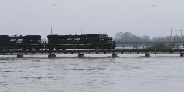 A freight train rolls over the swollen Pearl River towards Jackson, Miss., Sunday, Feb. 16, 2020.