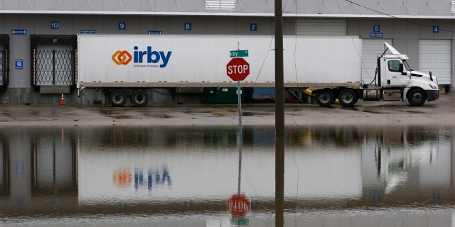 A parked tractor trailer's reflection is seen on a flooded street in downtown Jackson, Miss., as flooding from the Pearl River continues to impact several communities along its bank, Sunday, Feb. 16, 2020.