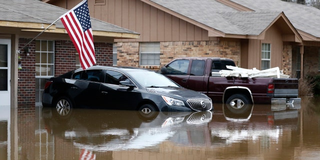 Abandoned vehicles are semi submerged in floodwater from the Pearl River in northeast Jackson, Miss., Sunday, Feb. 16, 2020.