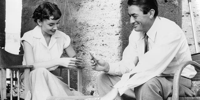 Audrey Hepburn plays cards with Gregory Peck in a scene from the film "Roman Holiday," 1953.