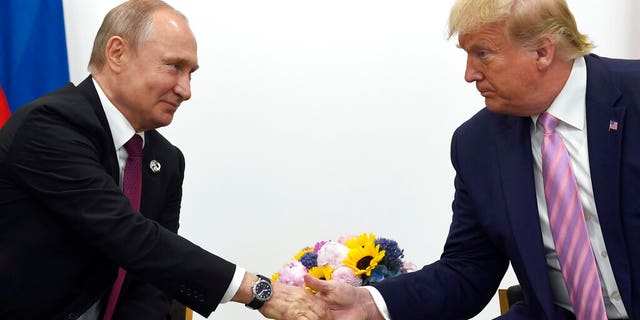 DOSSIER - En ce 28 juin 2019, photo d'archive, le président Donald Trump, à droite, serre la main du président russe Vladimir Poutine, à gauche, lors d'une réunion bilatérale en marge du G-20.  (AP Photo/Susan Walsh, Fichier)