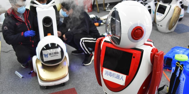 Technicians work on a second-generation disinfection robot in a technological company in Qingdao, east China's Shandong Province, Feb. 11, 2020. Qingdao has called on tech companies to research, develop and refit disinfection robots which can replace human in disinfection operations. Some of the robots have been put into use in the isolation areas of several hospitals.