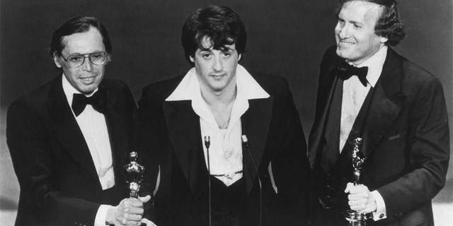 Sylvester Stallone, with producers Irwin Winkler (L), and Robert Chartoff (R), receive the Best Picture award for their movie Rocky during the 49th Academy Awards ceremony. (Photo by Axel Koester/Sygma via Getty Images)