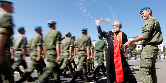 An Orthodox priest blesses Russian paratroopers marching during 2017 Paratroopers' Day celebrations, the annual holiday of Russian Airborne Troops, at their military unit in the southern city of Stavropol, Russia. 