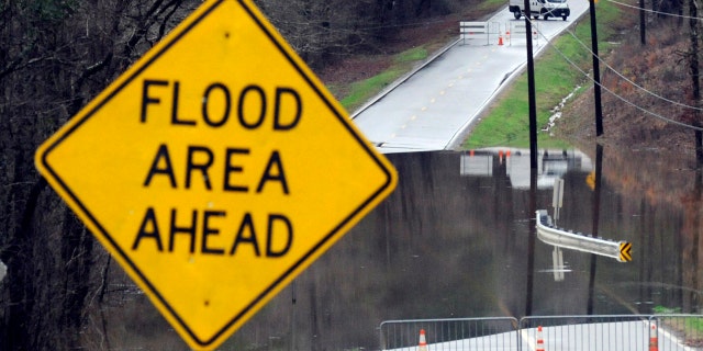 Vehicles turn around on a road blocked by floodwaters in Helena, Ala., on Tuesday, Feb. 11, 2020.