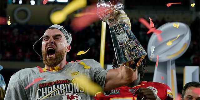 Kansas City Chiefs' Travis Kelce hoists the trophy after defeating the San Francisco 49ers in the NFL Super Bowl 54 football game Sunday, Feb. 2, 2020, in Miami Gardens, Fla. (AP Photo/David J. Phillip)