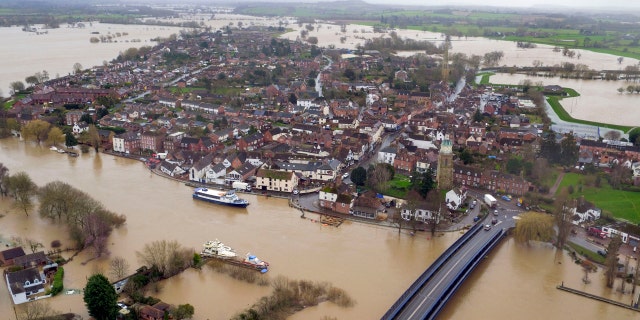 Floodwater surrounds the town of Upton-upon-Severn, England, with the normal course of the river Severn running horizontally under the road bridge, in the aftermath of Storm Dennis, in this photo taken with a drone Thursday, Feb. 20, 2020.