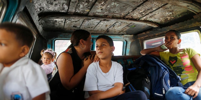 Passengers ride on public transport in Caracas, Venezuela on Wednesday. Families have been split up with at least 4.5 million Venezuelans fleeing crumbling public services. (AP Photo/Ariana Cubillos)
