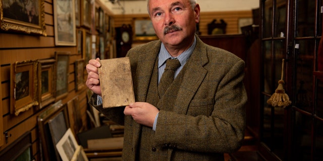 Militaria expert Adrian Stevenson of Hansons Auctioneers holds the diary written by British World War I soldier Arthur Edward Diggens.