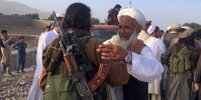 In this June 16, 2018 file photo, Taliban fighters gather with residents to celebrate a three-day cease fire marking the Islamic holiday of Eid al-Fitr, in Nangarhar province, east of Kabul, Afghanistan. (AP Photo/Rahmat Gul, File)