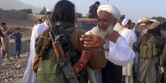 In this June 16, 2018 file photo, Taliban fighters gather with residents to celebrate a three-day cease fire marking the Islamic holiday of Eid al-Fitr, in Nangarhar province, east of Kabul, Afghanistan. (AP Photo/Rahmat Gul, File)