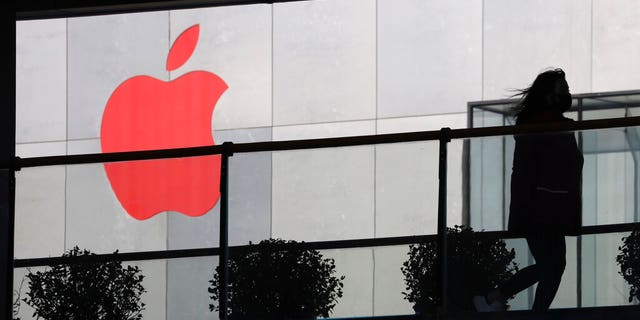 ملف - في هذه الصورة الأرشيفية في 6 ديسمبر 2018 ، امرأة تمر بجانب شعار Apple باللون الأحمر في بكين ، الصين. تغلق Apple مؤقتًا 42 متجرًا في البر الرئيسي للصين ، أحد أكبر أسواقها ، حيث ينتشر فيروس جديد بسرعة وارتفع عدد القتلى إلى 259 يوم السبت ، 1 فبراير 2020. ومكاتب الشركات ومراكز الاتصال في الصين حتى 9 فبراير "بناءً على قدر كبير من الحذر واستنادًا إلى أحدث النصائح من كبار خبراء الصحة." (AP Photo / Ng Han Guan، fil)