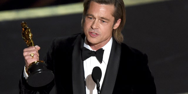 Brad Pitt accepts the award for best performance by an actor in a supporting role for 