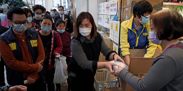 People queue up to buy face masks in Hong Kong, Friday, Feb. 7, 2020. (AP Photo/Kin Cheung)