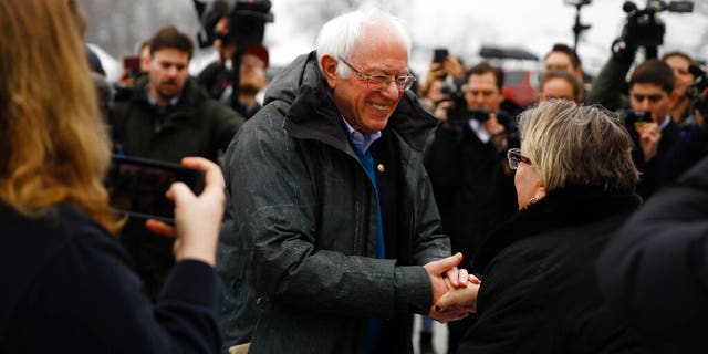 Democratic presidential candidate Sen. Bernie Sanders, I-Vt., meets with people outside a polling place where voters will cast their ballots in a primary election, in Manchester, N.H., Tuesday, Feb. 11, 2020. (AP Photo/Matt Rourke)