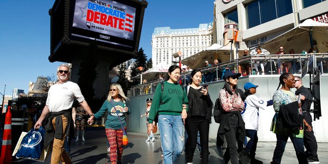 People walk near the Paris Las Vegas hotel casino, site of a Democratic presidential debate, Wednesday, Feb. 19, 2020, in Las Vegas. (AP Photo/John Locher)