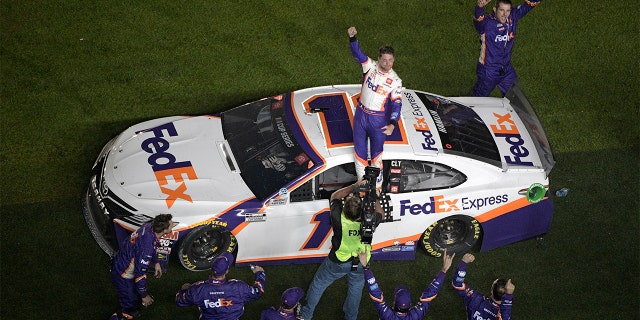 Denny Hamlin (11) celebrating in front of the grandstands. (AP Photo/Phelan M. Ebenhack)