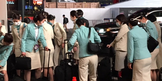 Asian airline crew members wear masks as they arrive at their New York City hotel, Feb. 12, 2020. (Dom Calicchio/Fox News)