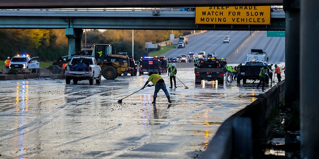 Workers clean water from the southbound lanes of 610 at Clinton Drive, Thursday, Feb. 27, 2020, in Houston. (Associated Press)