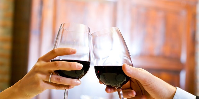 Couple toasting wine glasses in an elegant restaurant
