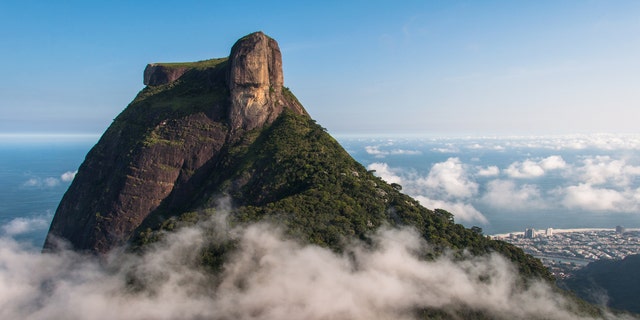 Social media commenters have scolded a rash tourist who posed at a nearly-vertical incline of the monolithic Pedra da Gávea mountain, pictured, in Rio De Janerio, Brazil.