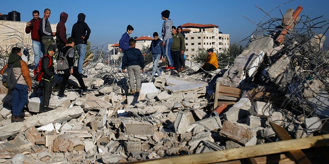 Palestinians inspect a house after it was demolished by the Israeli army in the West Bank city of Jenin on Thursday. (AP)