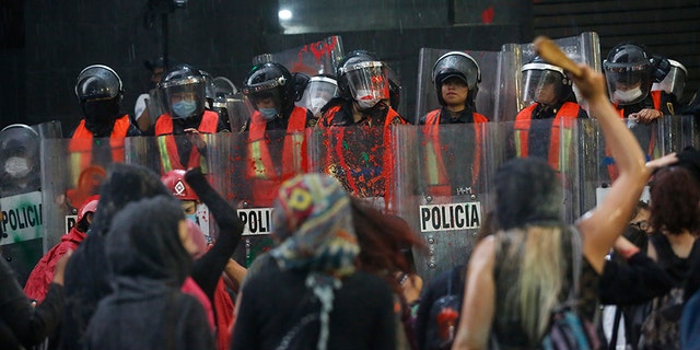 Riot police form a cordon during a demonstration by women against gender violence in Mexico City on Friday. (AP)