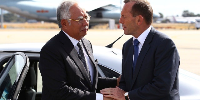 In this April 3, 2014, file photo, Australian then Prime Minister Tony Abbott, right, shakes hands with Malaysian then Prime Minister Najib Razak as Razak prepares to depart Australia after his visit during the search of the missing Malaysia Airlines flight MH370 at Perth International Airport, Australia.