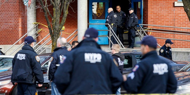 New York City police officers work the scene of a police-involved shooting outside the 41st precinct Sunday in the Bronx. (AP Photo/John Minchillo)