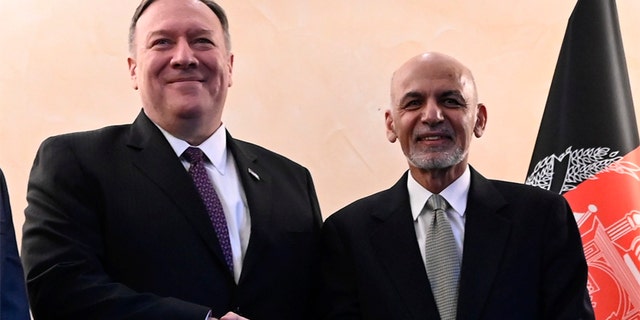 Former U.S. Secretary of State Mike Pompeo, left, shakes hands with Afghan President Ashraf Ghani.