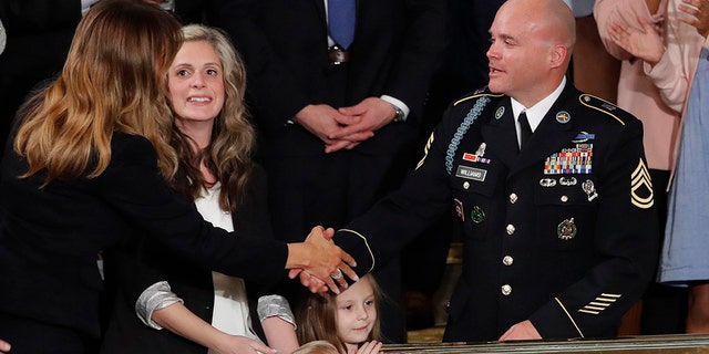 As Amy Williams watches, her husband Sgt. 1st Class Townsend Williams, greets first Lady Melania Trump after he surprised her by appearing at the State of the Union address by President Donald Trump in a joint session of Congress on Capitol Hill in Washington, Tuesday, Feb. 4, 2020. Their children Rowan, 3, and Elliana, watch. (AP Photo/J. Scott Applewhite)