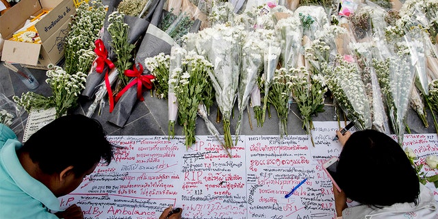 People write notes and leave flowers at the scene of the shooting. (AP)