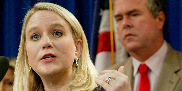 ​​​​​​​Tiffany Carr, then the executive director of Florida Coalition Against Domestic Violence, left, speaks at a news conference held by Gov. Jeb Bush, background right, Sept. 28, 2004, in Tallahassee, Fla. (Associated Press)