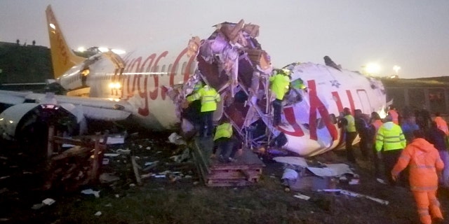 Officials working around the crash site Istanbul Sabiha Gokcen International Airport. (Anadolu Agency via Getty Images)
