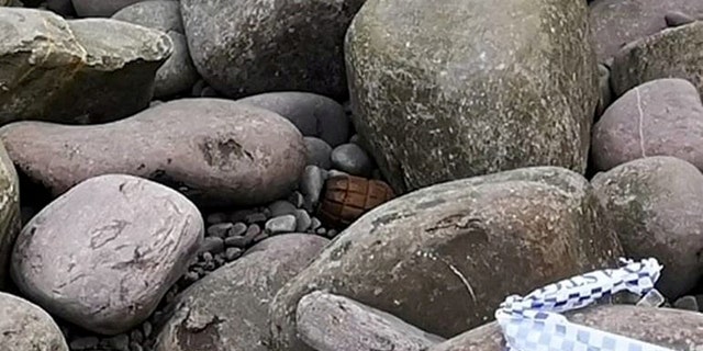 A WWI hand grenade discovered among rocks on a beach at Culver Cliff, Minehead, north Somerset, apparently uncovered by the recent storms. (Credit: SWNS)