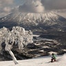 A man snowboards down a slope overlooking Mount Yotei at a ski resort in Niseko, Hokkaido, Japan, Feb. 5, 2020. 