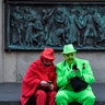 Two revelers wait at a monument for the start of the traditional alternative carnival ghost parade in Cologne, Germany, Feb. 15, 2020. 