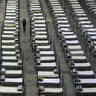 A worker walks among beds in a convention center that has been converted into a temporary hospital in Wuhan, China, Feb. 4, 2020. 