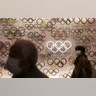 Two people wear masks as they visit the newly opened Japan Olympic Museum located near the New National Stadium, in Tokyo, Feb. 23, 2020. 