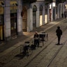 A man sits alone outside a bar at the Naviglio Grande canal in Milan, Italy, Feb. 24, 2020.