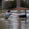 Blaine Henderson reaches for a mailbox as he and his friend Jonah Valdez play in the floodwaters of the Pearl River in Jackson, Mississippi, Feb. 16, 2020. 
