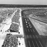The green flag starts the first Daytona 500 in 1959. Lee Petty, driving an Oldsmobile, beat Johnny Beauchamp's Ford Thunderbird by inches to take the victory. Both hardtops and convertibles ran in the race, an official "sweepstakes" race for both NASCAR Grand National (now Cup) and Convertible Divisions.