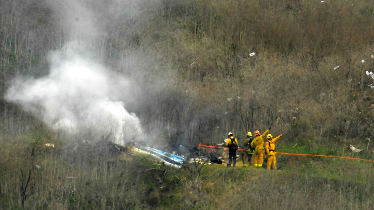 FILE - In this Jan. 26, 2020, file photo, firefighters work the scene of a helicopter crash where former NBA basketball star Kobe Bryant died in Calabasas, Calif. Los Angeles County Sheriff Alex Villanueva says eight deputies allegedly took or shared graphic photos of the helicopter crash scene, but he ordered them deleted. (AP Photo/Mark J. Terrill, File)