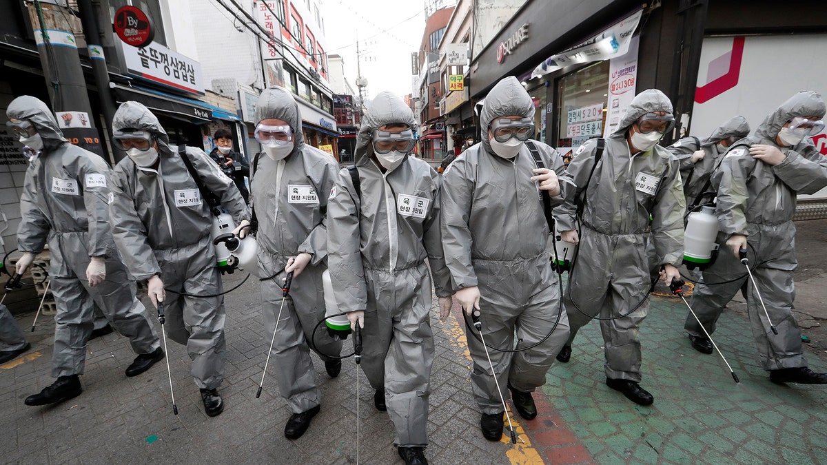 Army soldiers wearing protective suits spray disinfectant as a precaution against the new coronavirus at a shopping street in Seoul, South Korea, Wednesday, March 4, 2020 - file photo.